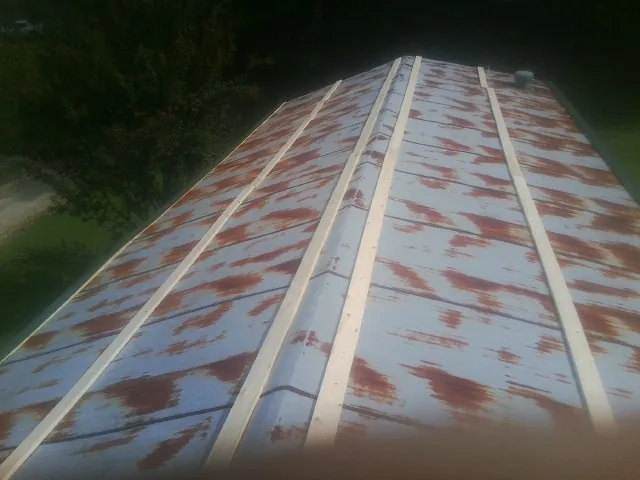 Rusted metal roof panels with new wood purlins before replacement — Storm Damage Roof Repair in Smithfield by Roofing Brothers